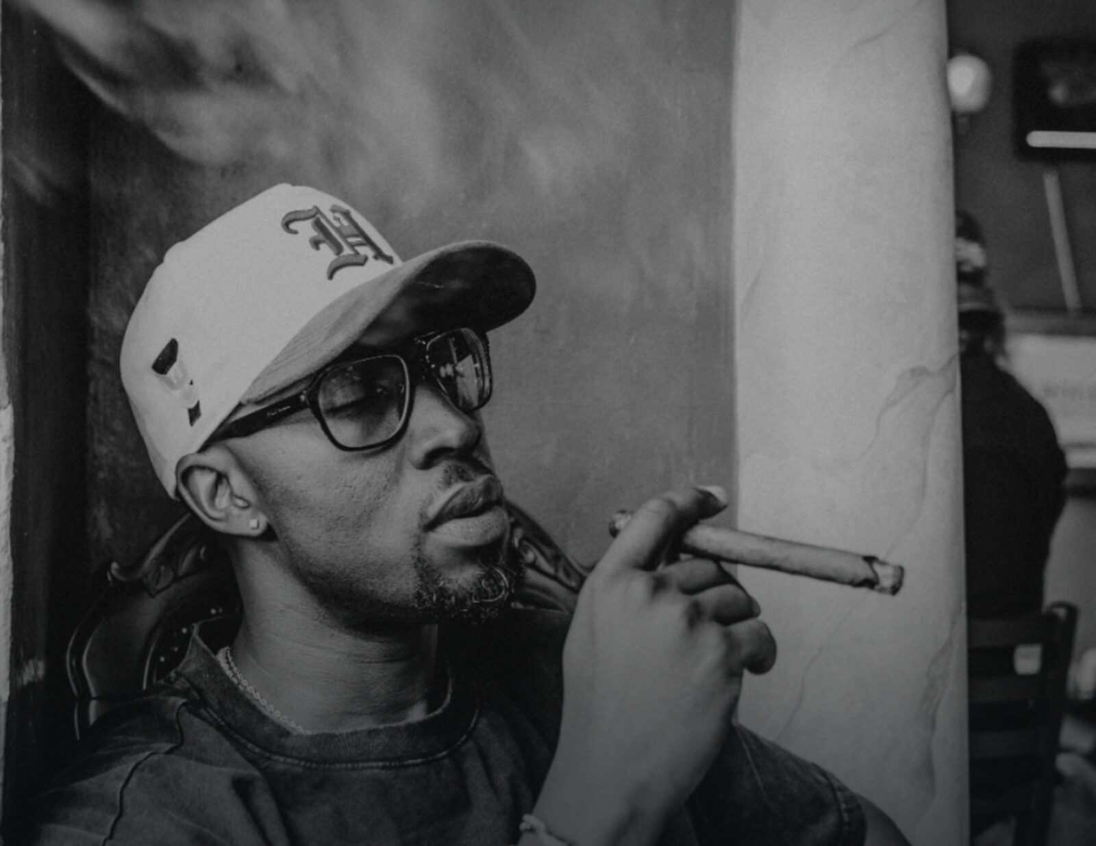 Black and white portrait of Ian Bennett with a cigar, a visual teaser for The Roaring Lion